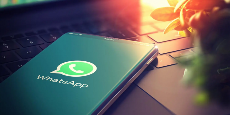 Teléfono con el logo de WhatsApp sobre una computadora para referenciar la integración Whathub