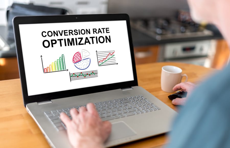 Persona en frente de una computadora, analizando cómo optimizar su tasa de conversión